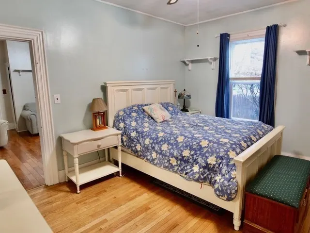 a bedroom with a bed and a mirror on dresser