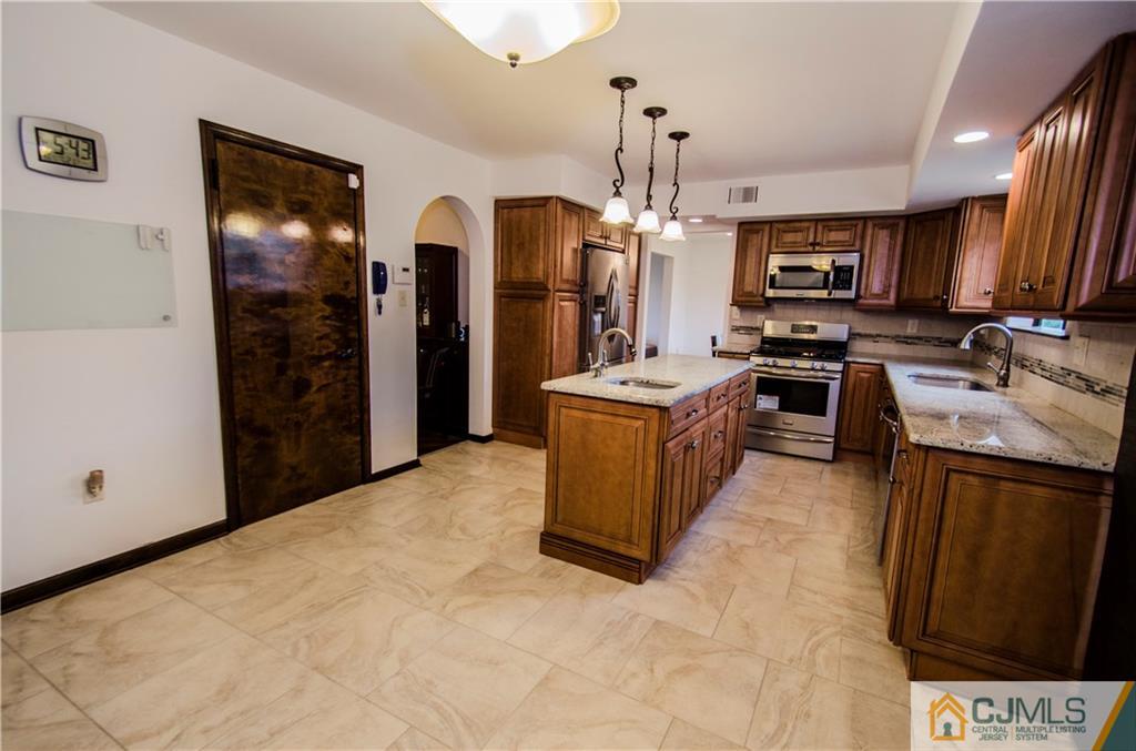 29 Yard Road Pennington, NJ 08534 - Photo 7 of 25 a large kitchen with stainless steel appliances kitchen island granite countertop a stove a sink dishwasher and a refrigerator with wooden floor