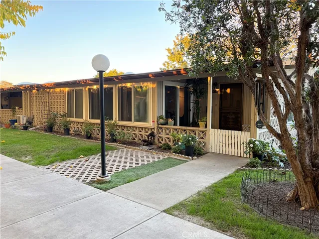 a front view of a house with garden and plants
