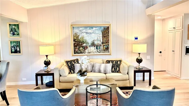 a living room with couches a computer and a window