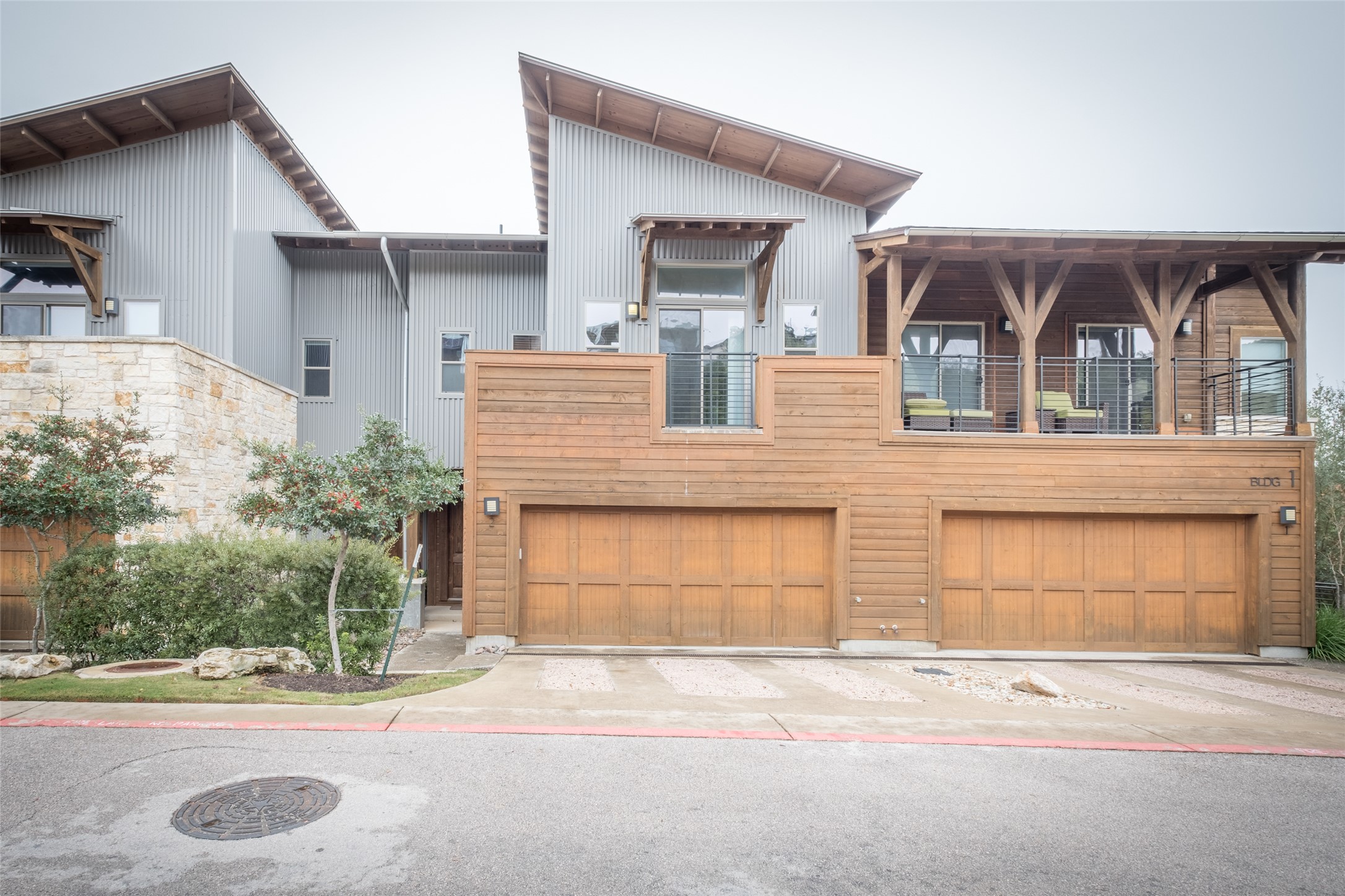 8110 Ranch Road 2222, Unit 2 Austin, TX 78730 - Photo 1 of 1 Modern townhome boasts striking architectural lines and inviting wood accents, featuring multiple garages.