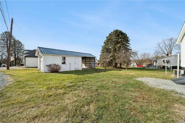 a view of a house with backyard and trees