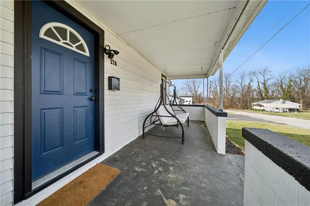 a view of a porch with furniture and a yard