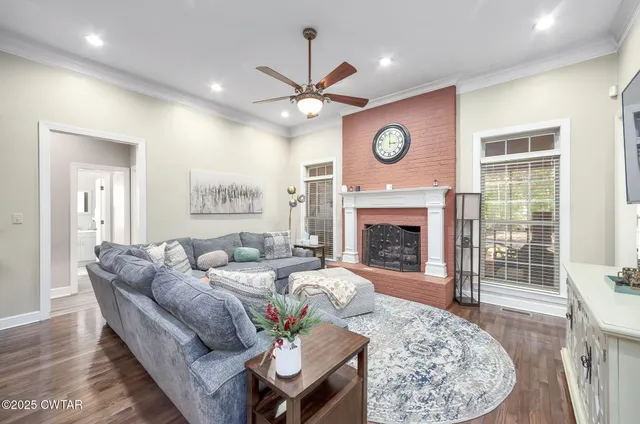 a living room with furniture a fireplace and a large window