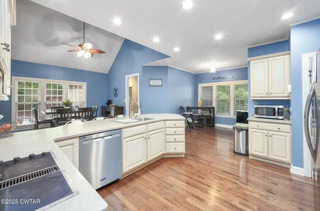 a large kitchen with white cabinets and stainless steel appliances