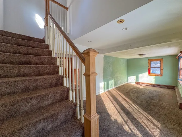 a view of a hallway with stairs and a chandelier
