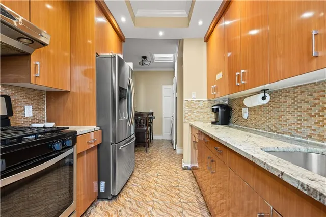 a kitchen with stainless steel appliances granite countertop a sink and a refrigerator