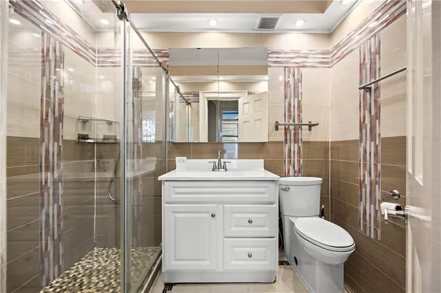 a bathroom with a granite countertop toilet sink and shower