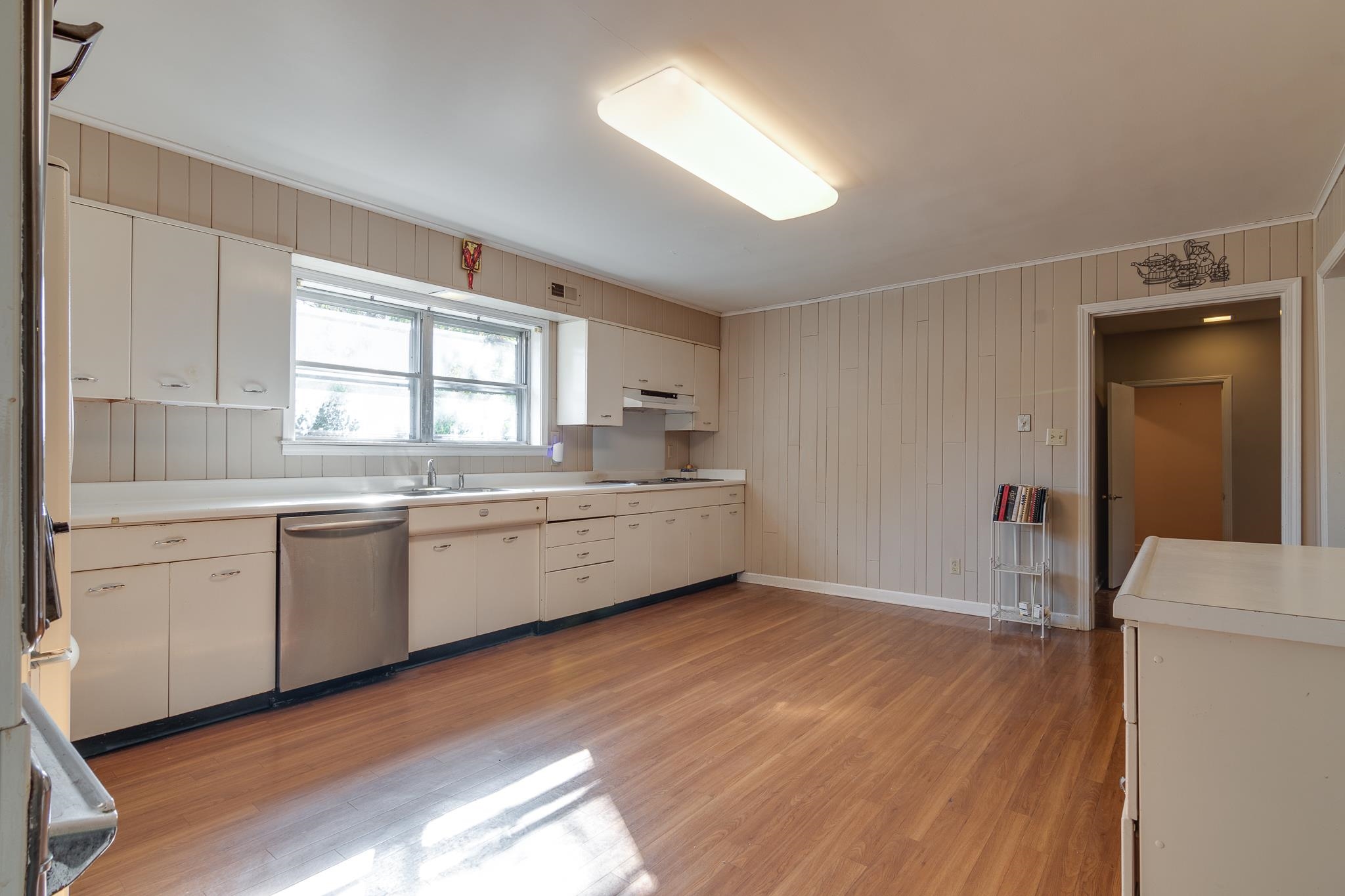 121 South Yates Road Memphis, TN 38120 - Photo 10 of 38 a kitchen with a sink cabinets wooden floor and a window