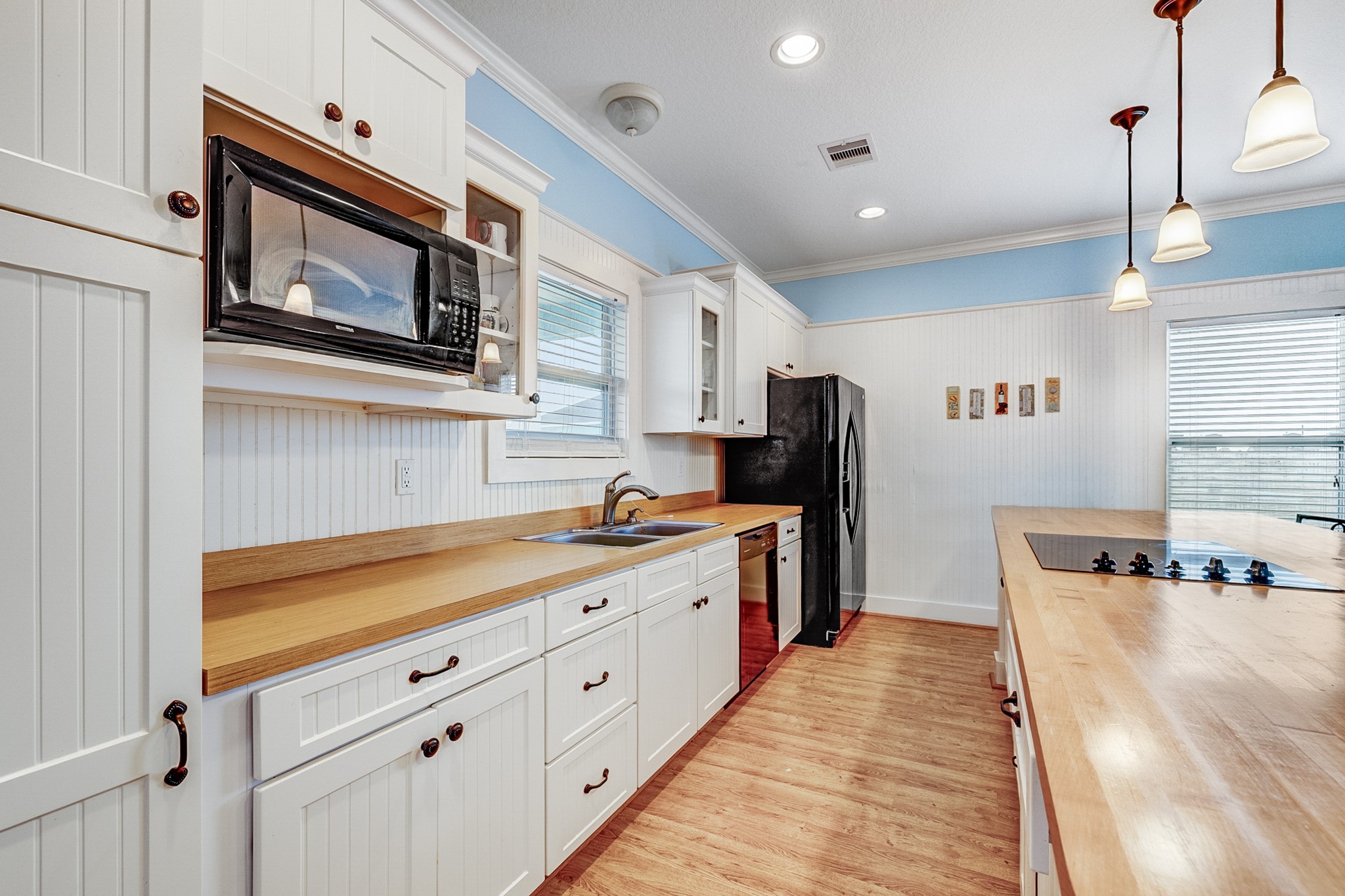 935 Clara Street Crystal Beach, TX 77650 - Photo 9 of 30 a kitchen with stainless steel appliances granite countertop a refrigerator a stove and a wooden floors