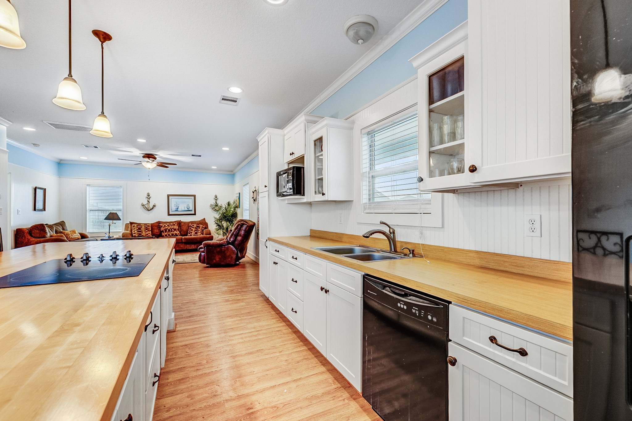 935 Clara Street Crystal Beach, TX 77650 - Photo 10 of 30 a large kitchen with stainless steel appliances granite countertop a lot of counter space and wooden floor
