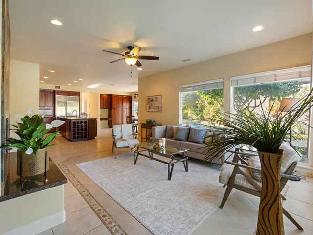 a living room with furniture a window and a potted plant