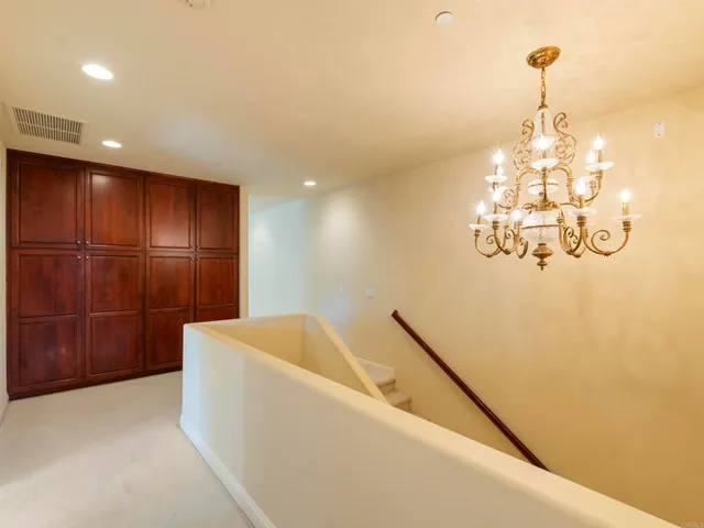 a spacious bedroom with a bed and a chandelier