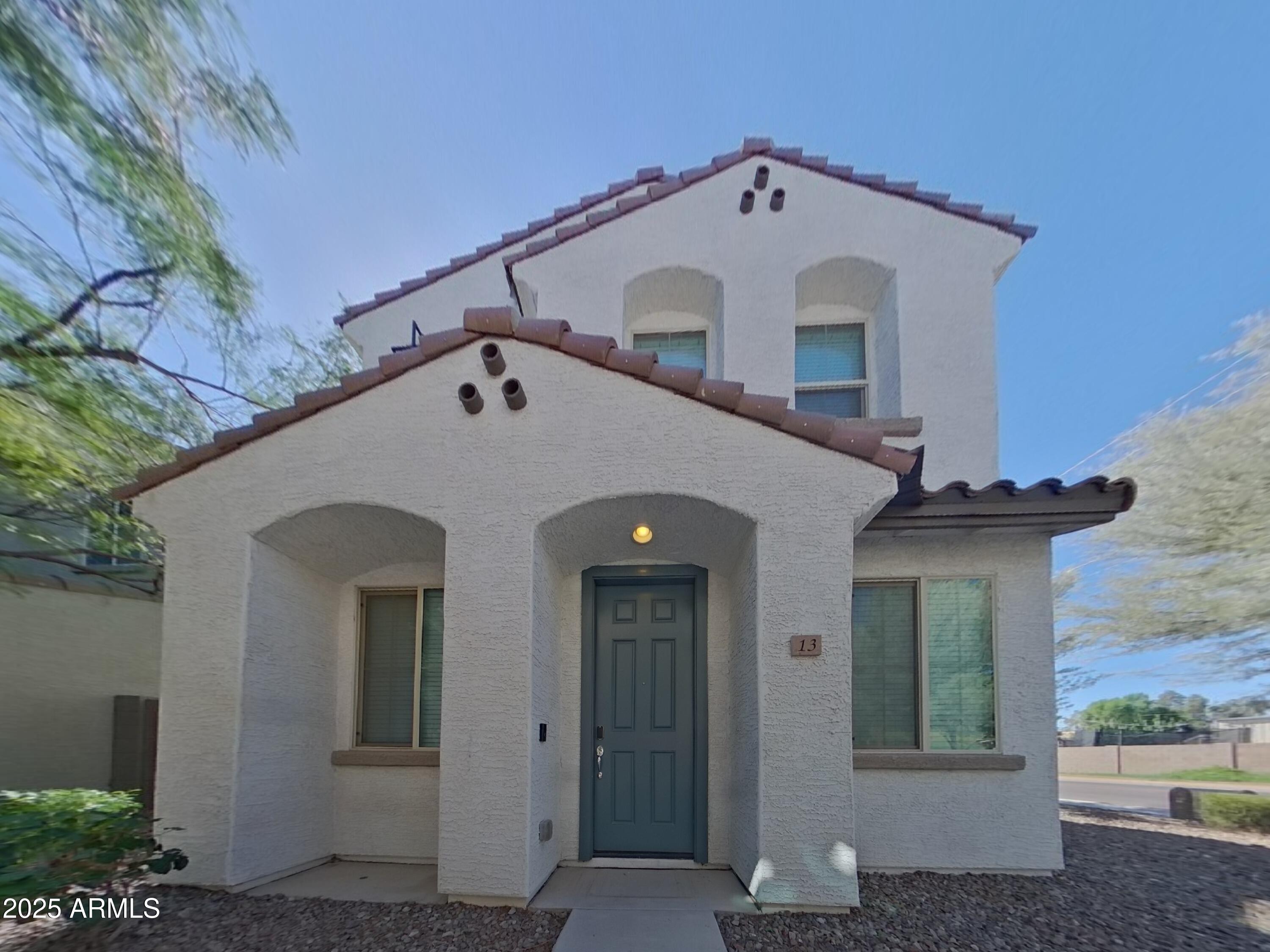 a view of a white house with a small yard