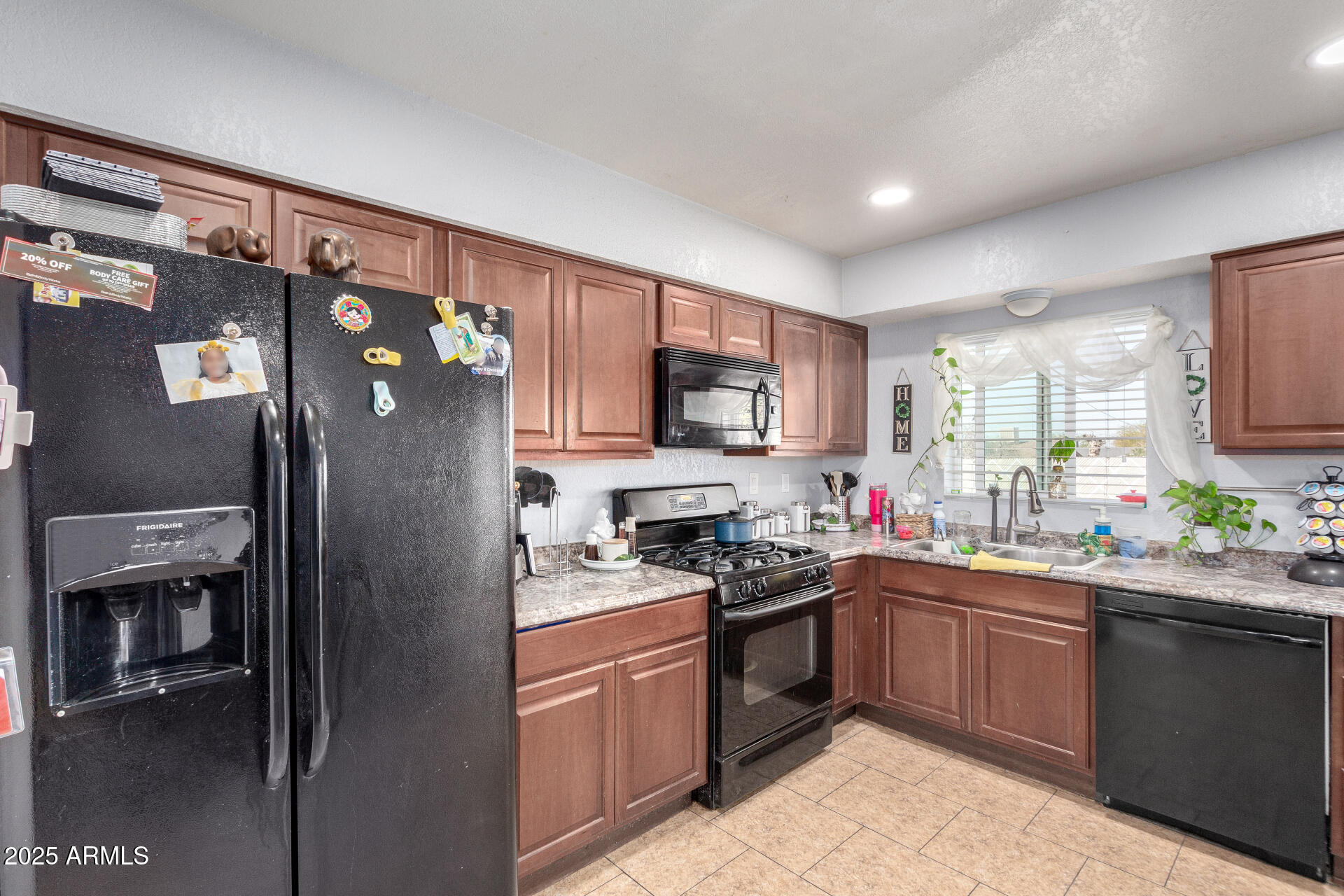 12608 West Lower Buckeye Road Avondale, AZ 85323 - Photo 12 of 26 a kitchen with stainless steel appliances granite countertop a refrigerator sink and stove
