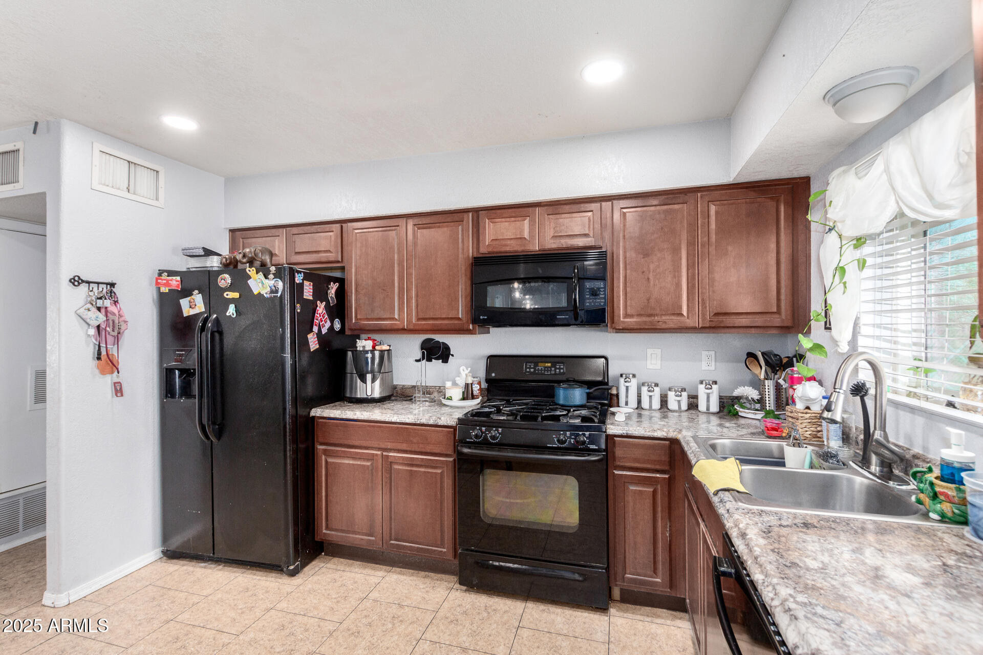 12608 West Lower Buckeye Road Avondale, AZ 85323 - Photo 13 of 26 a kitchen with stainless steel appliances granite countertop a refrigerator stove and sink