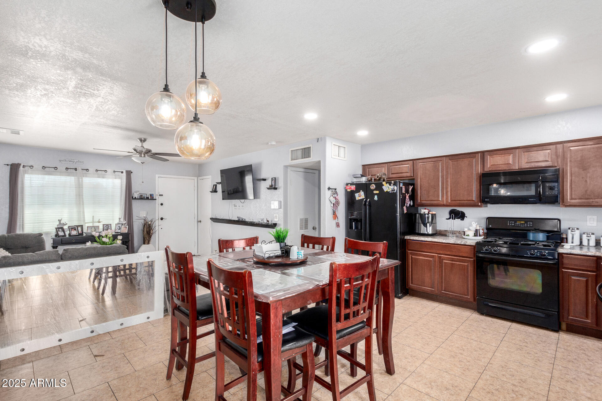 12608 West Lower Buckeye Road Avondale, AZ 85323 - Photo 14 of 26 a kitchen with stainless steel appliances a dining table chairs and stove