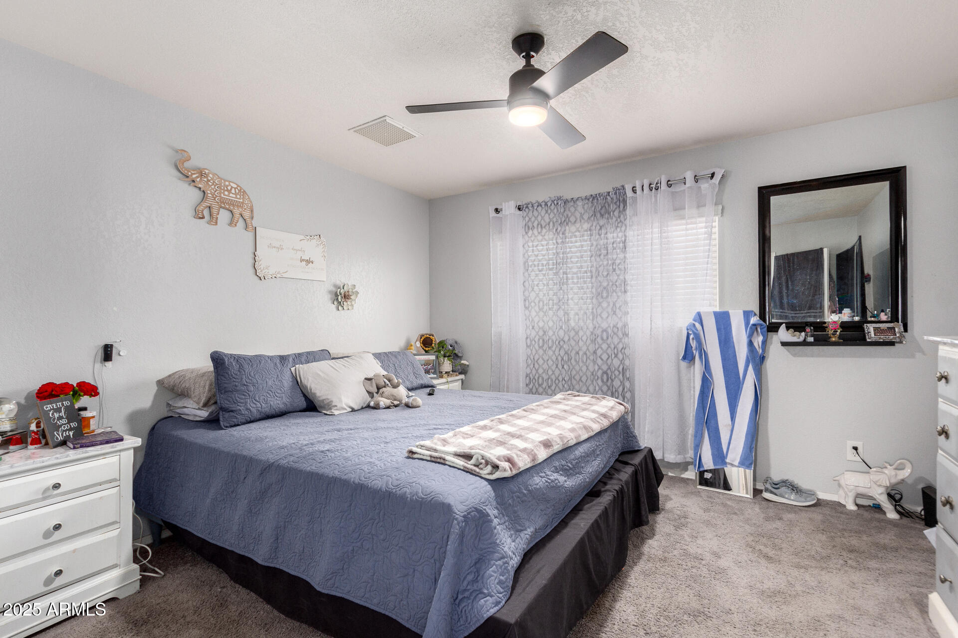 12608 West Lower Buckeye Road Avondale, AZ 85323 - Photo 15 of 26 a bedroom with a bed and a chandelier