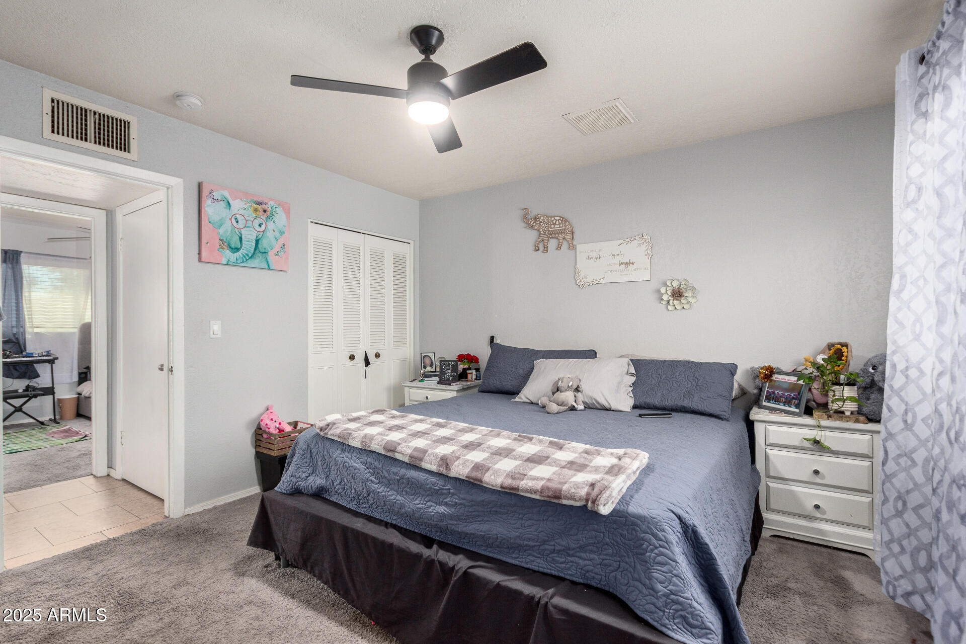12608 West Lower Buckeye Road Avondale, AZ 85323 - Photo 17 of 26 a bedroom with a bed and a chandelier