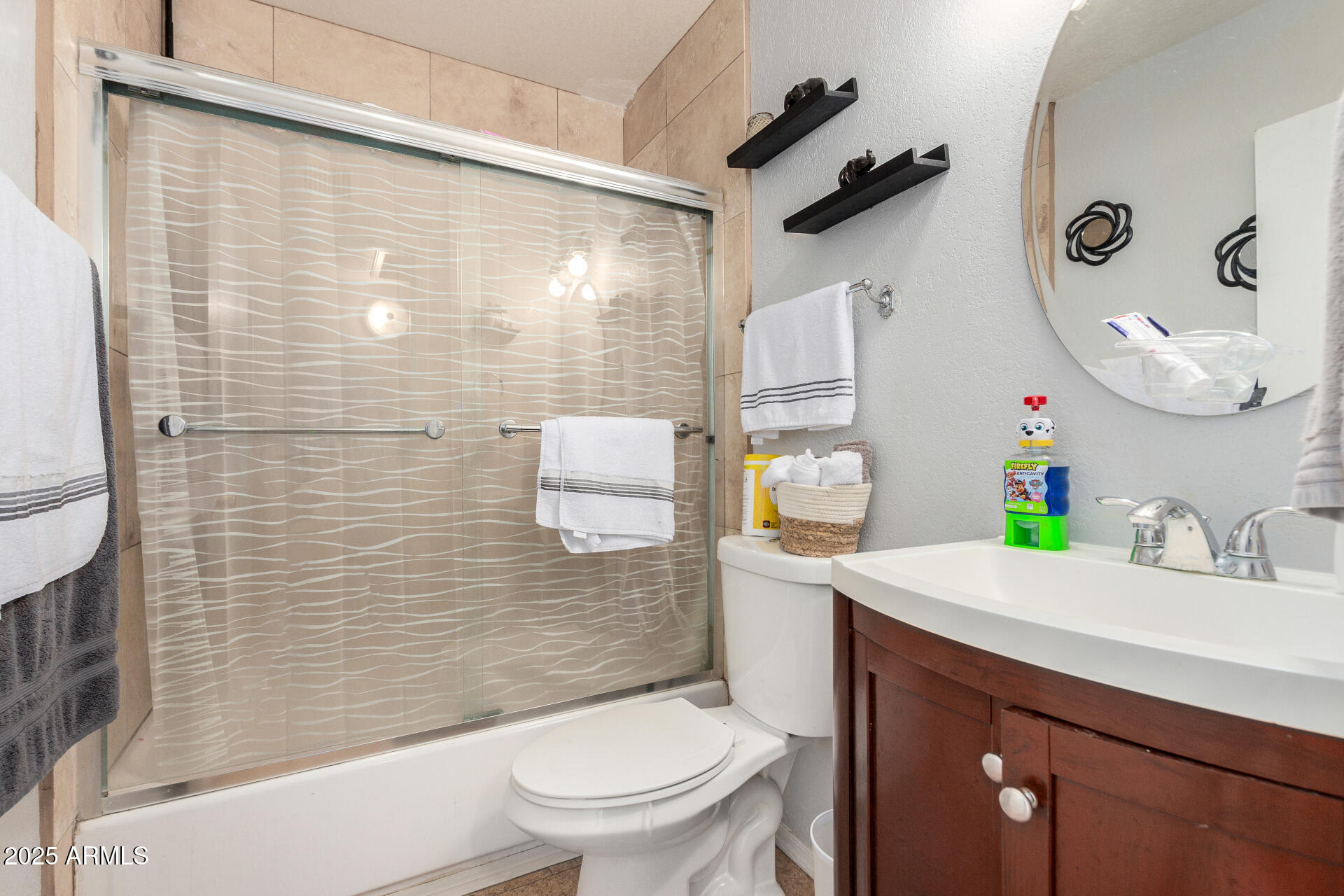 12608 West Lower Buckeye Road Avondale, AZ 85323 - Photo 21 of 26 a bathroom with a sink a toilet and shower curtain