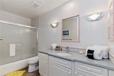 a bathroom with a granite countertop sink a toilet and a mirror
