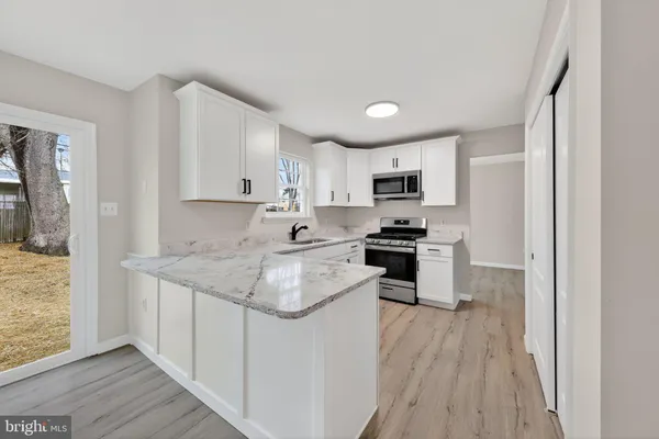 a kitchen with granite countertop a sink stove and refrigerator