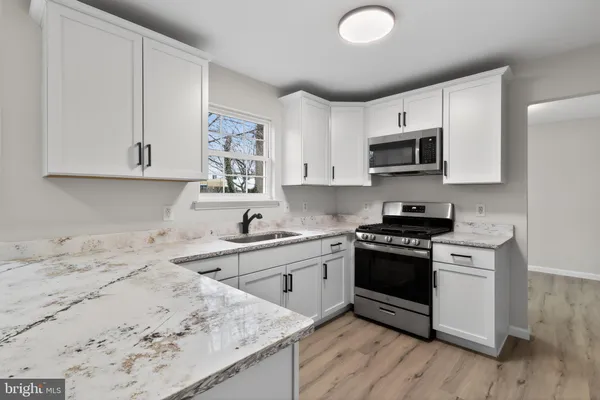 a kitchen with stainless steel appliances granite countertop a stove a sink and a microwave