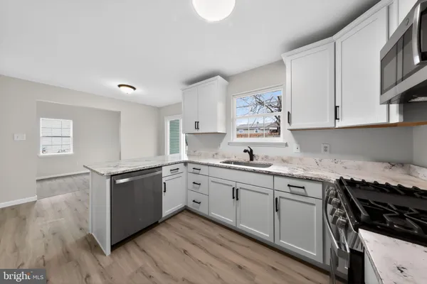 a kitchen with stainless steel appliances granite countertop a stove and a sink