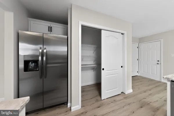 a kitchen with a refrigerator and wooden floor