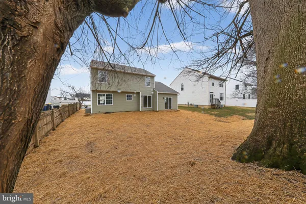 a view of a house with a yard and large trees