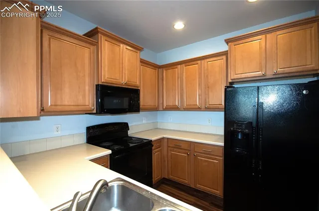 a kitchen with granite countertop cabinets stainless steel appliances a sink and a window