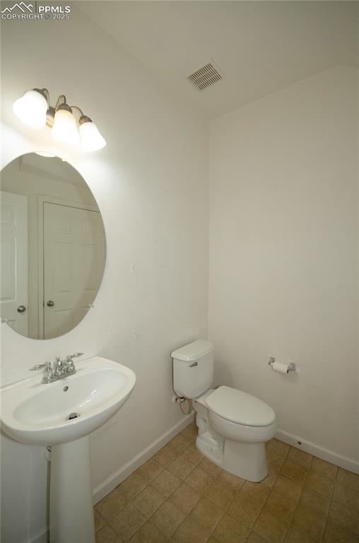 1316 Walters Point Monument, CO 80132 - Photo 10 of 33 a bathroom with a toilet sink and mirror