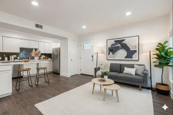 a living room with furniture and a painting on the wall