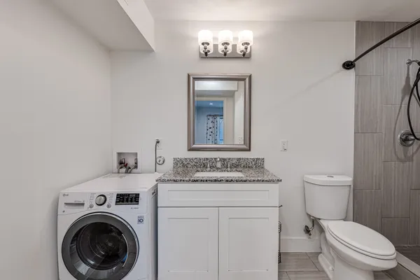 a bathroom with a toilet sink vanity and mirror
