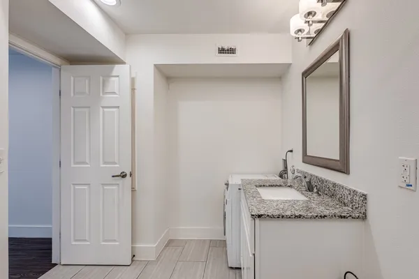 a bathroom with a granite countertop sink and a mirror