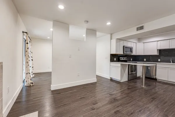 a kitchen with granite countertop a refrigerator and a stove top oven