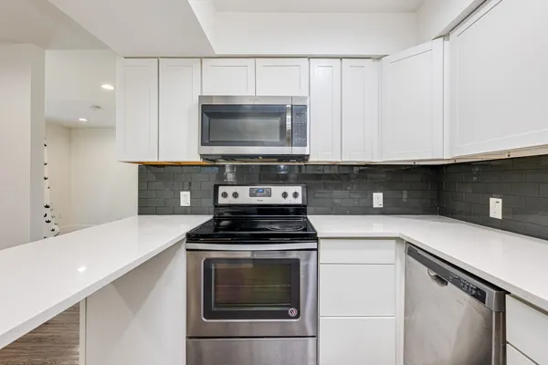 a kitchen with cabinets appliances and a sink