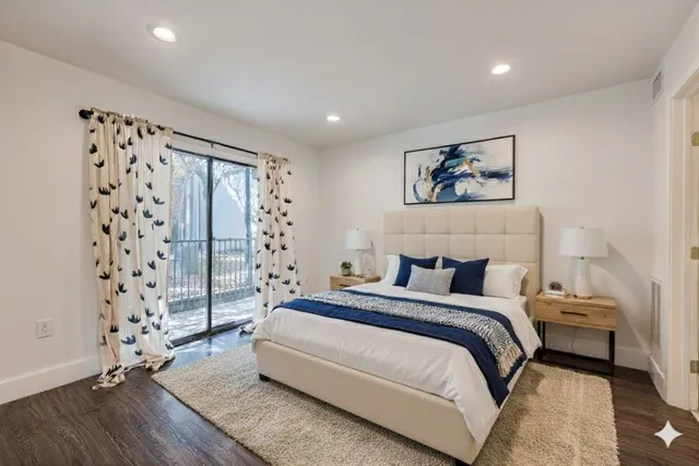 a spacious bedroom with a bed and a wooden floor