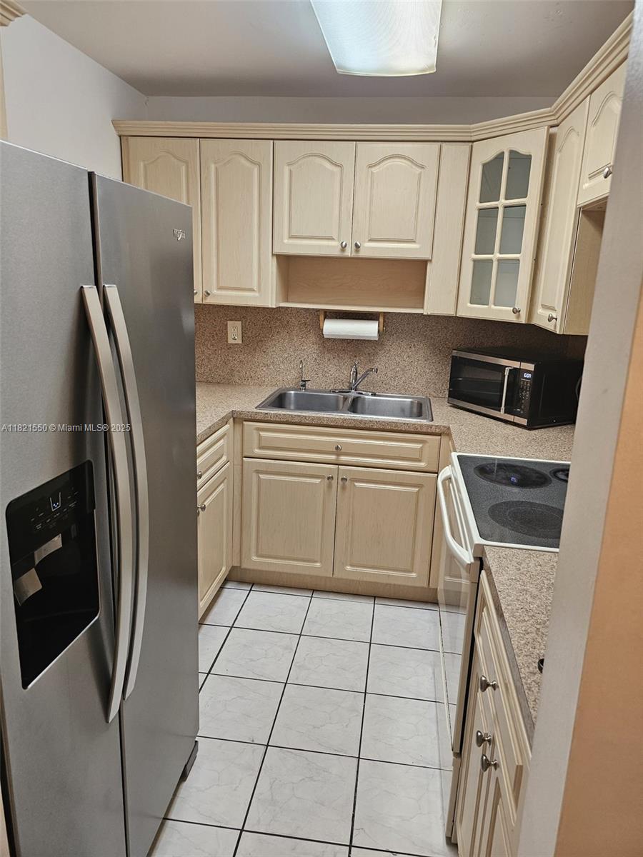 1555 West 44th Place, Unit 221B Hialeah, FL 33012 - Photo 4 of 15 a kitchen with stainless steel appliances a refrigerator sink and cabinets