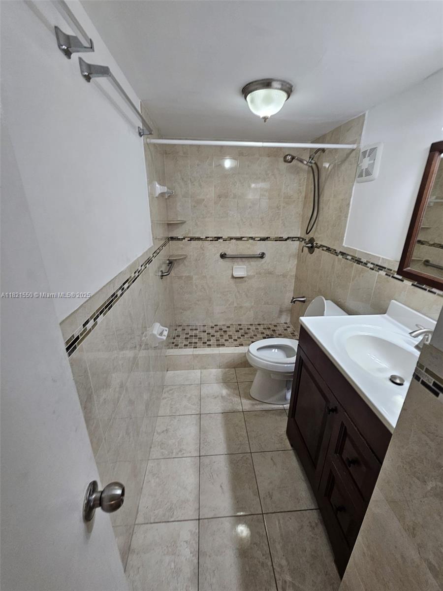 1555 West 44th Place, Unit 221B Hialeah, FL 33012 - Photo 10 of 15 a bathroom with a granite countertop sink a toilet and a mirror