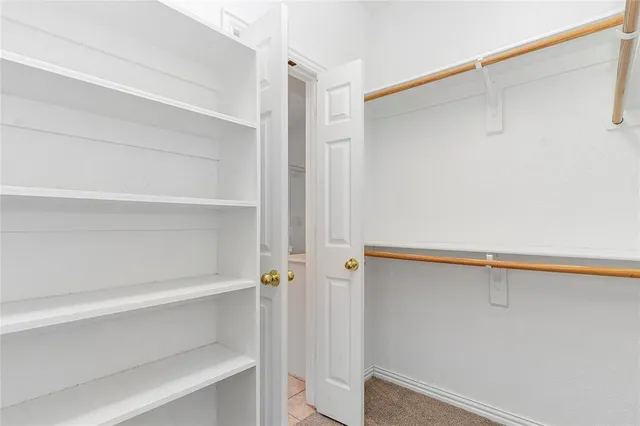a view of walk in closet with empty racks