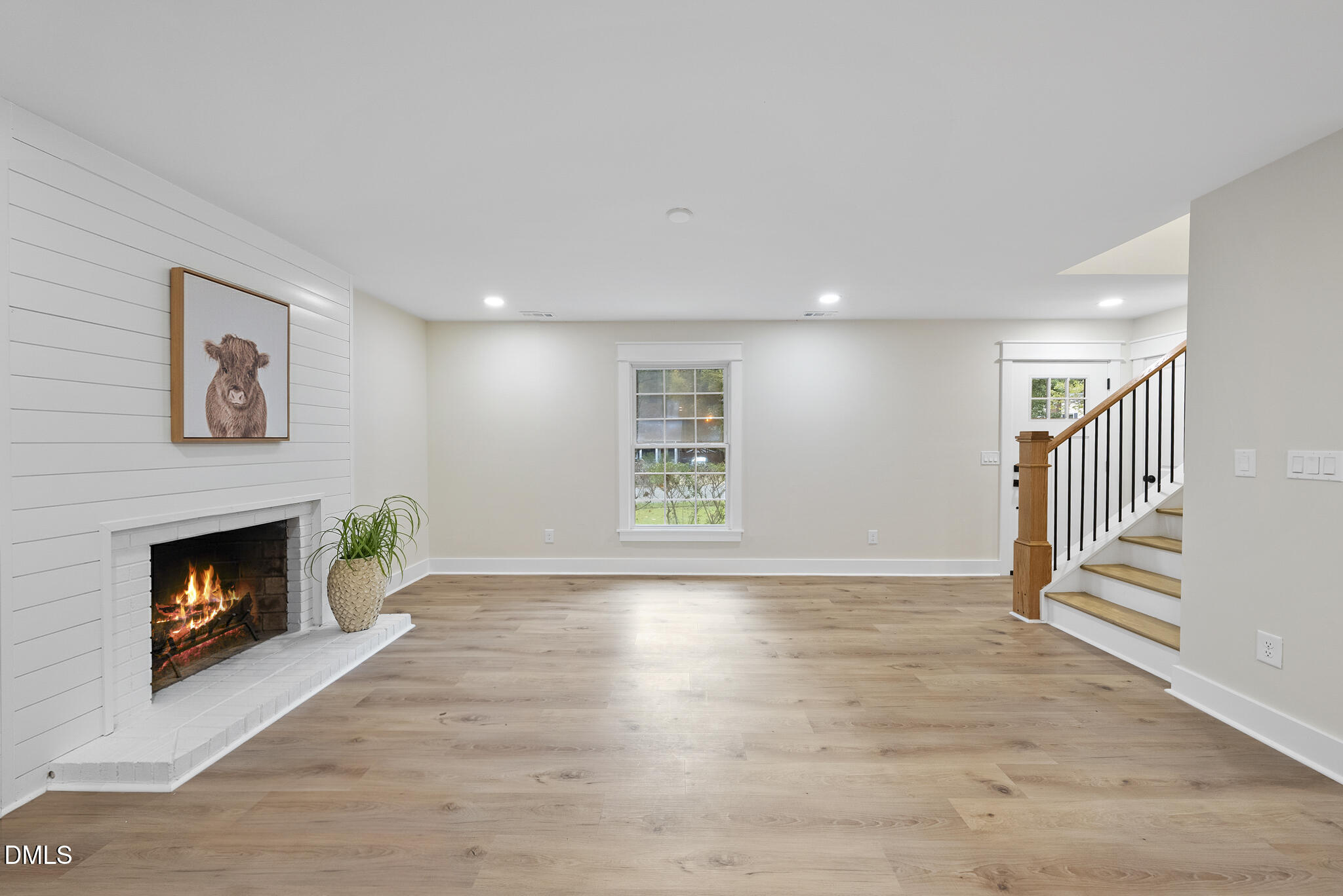 7804 Brandyapple Drive Raleigh, NC 27615 - Photo 19 of 58 a view of an empty room with wooden floor fireplace and a window