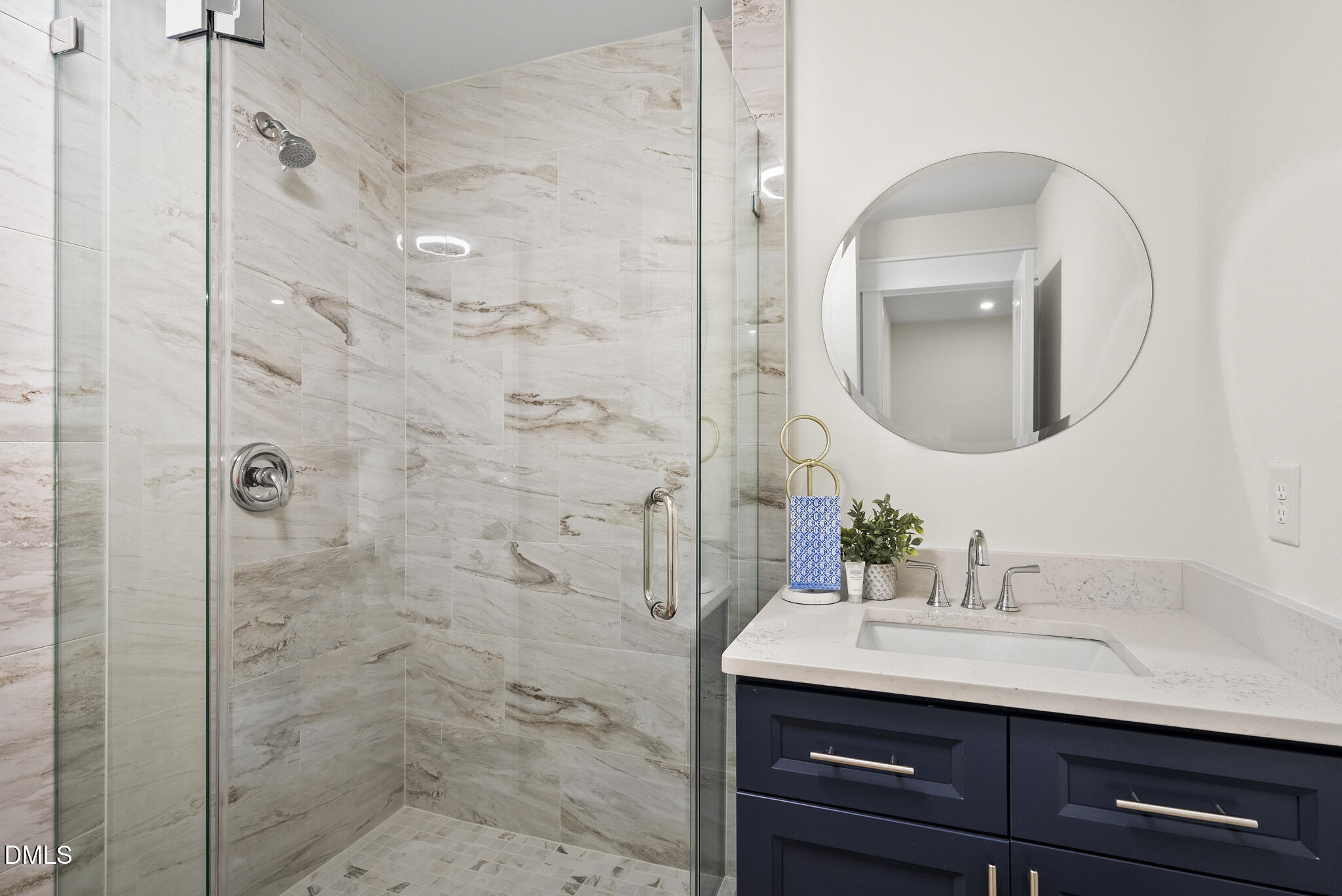 7804 Brandyapple Drive Raleigh, NC 27615 - Photo 28 of 58 a bathroom with a sink a mirror a vanity and shower