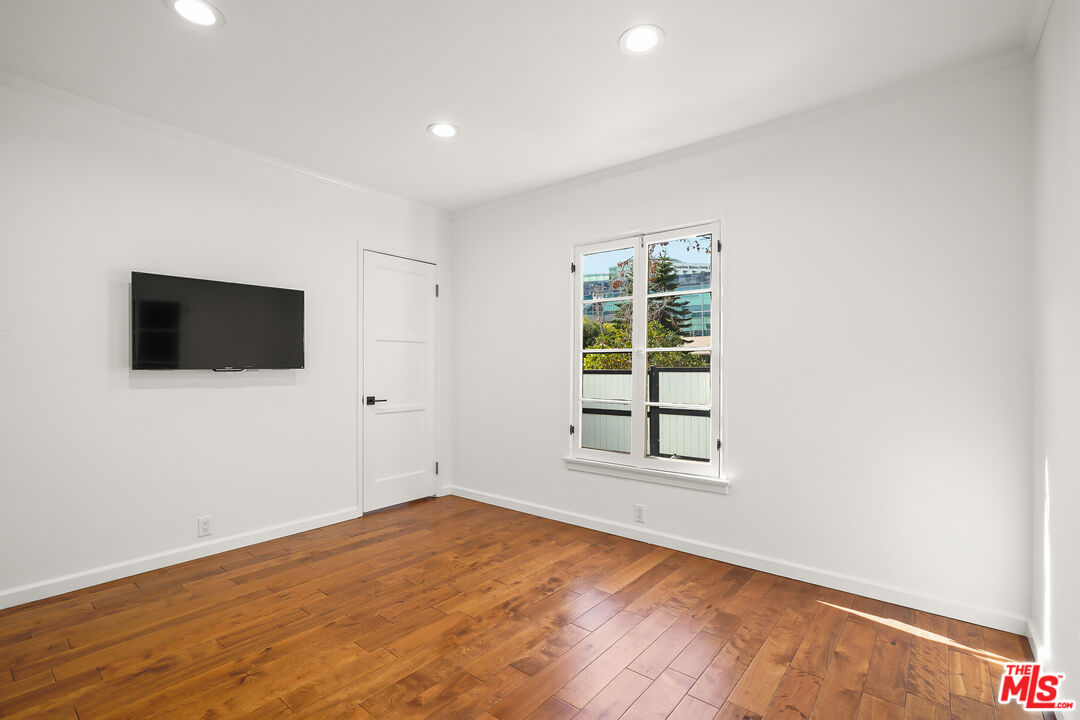 318 Huntley Drive West Hollywood, CA 90048 - Photo 12 of 25 an empty room with wooden floor and windows