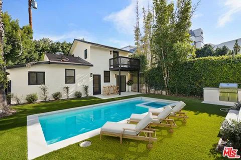a view of a house with a yard patio and swimming pool
