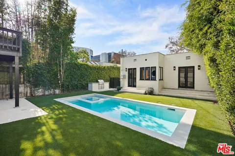 a view of a house with swimming pool and a yard