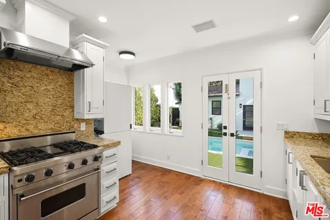a kitchen with granite countertop a stove and a wooden floors