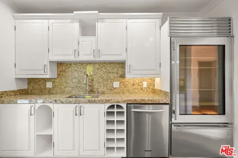 a kitchen with stainless steel appliances granite countertop a stove and white cabinets