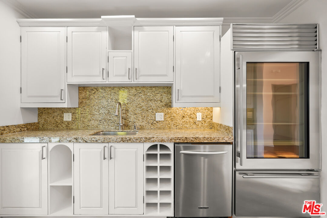 318 Huntley Drive West Hollywood, CA 90048 - Photo 7 of 25 a kitchen with stainless steel appliances granite countertop a stove and white cabinets