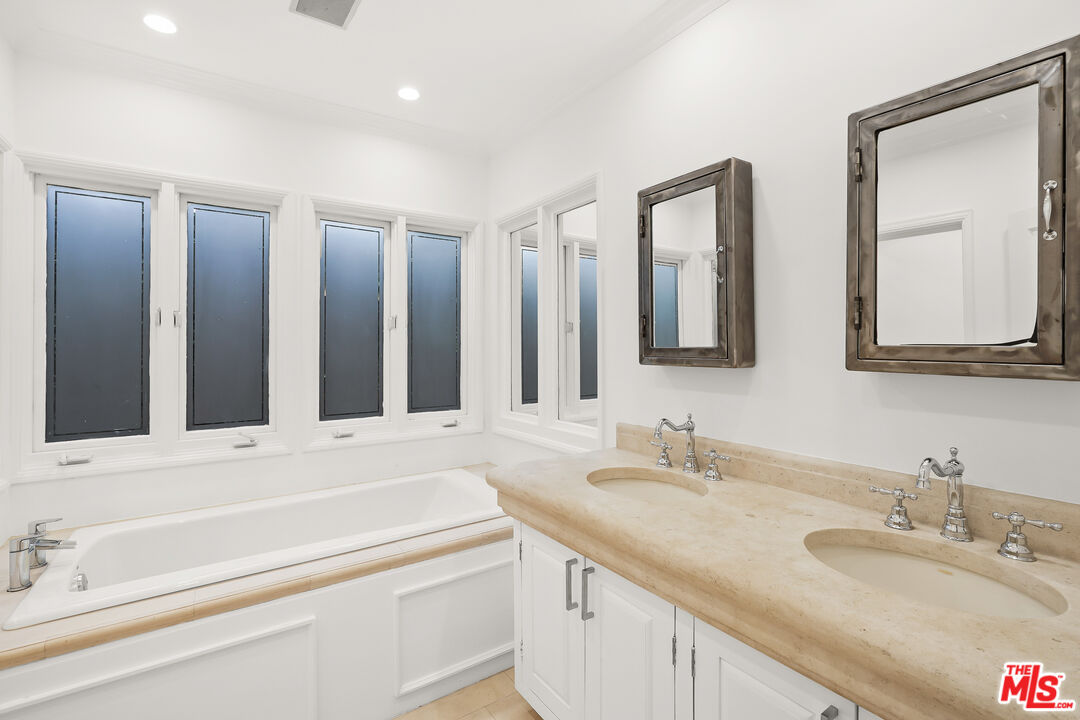 318 Huntley Drive West Hollywood, CA 90048 - Photo 9 of 25 a bathroom with double vanity sinks and a mirror